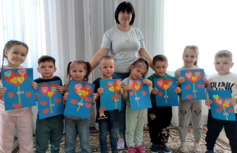 Зображено дітей, які тримають в руках  паперові аплікації