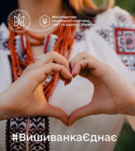 Зображено дівчину у вишиванці, яка склала долоні у формі серця.