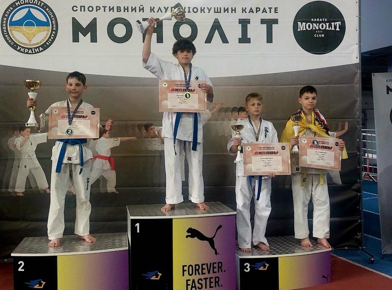 Зображено переможців змагань з кубками і дипломами на п'єдесталі