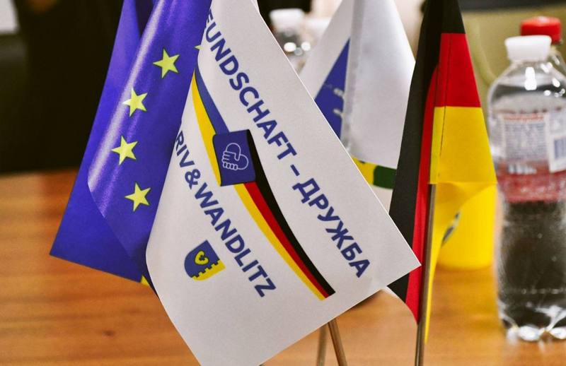 Ілюстративне фото прапорців Євросоюзу, Німеччини, Макарівської громади та "Макарів і Вандліц - дружба"