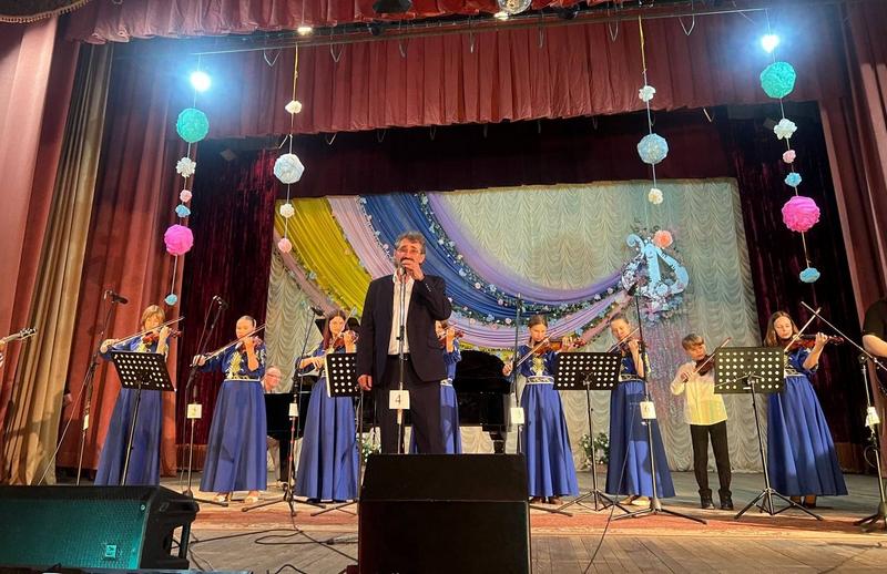 Директор школи мистецтв співає під акомпанемент ансамблю дітей-скрипалів