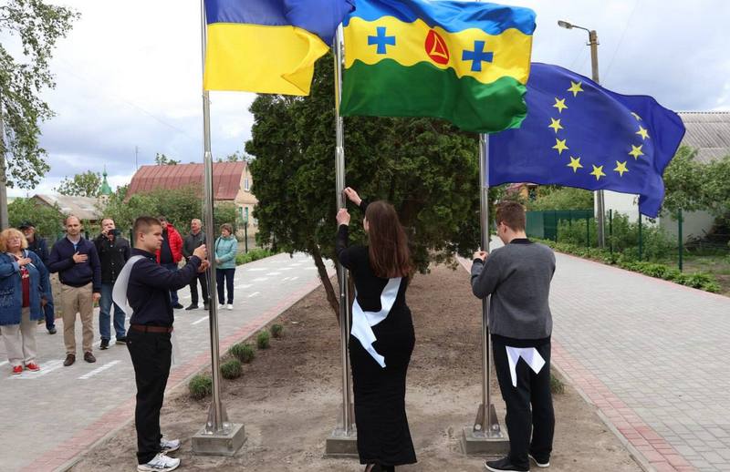 Випусники урочисто підіймають прапори України, Макарівської громади та Євросоюзу