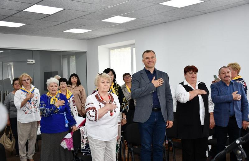 Присутні на випуску стоячи приклавши руки до сердець слухають Гімн України