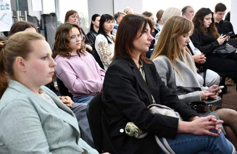 Профільний план зали засідань, де присутні — переважно молодь, студентки та місцеві жителі — уважно слухають презентацію проєктів просторового планування Макарівщини
