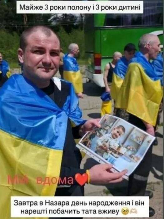 Звільнений з полону Максим Матвійчук тримає в руках фото свого сина