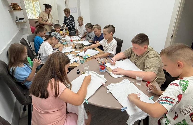 Діти ветеранів та захисників України захоплено розписують білі футболки акриловими фарбами під час творчої зустрічі у Ветеранському просторі «Серед своїх»