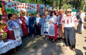 Учасники обласного фестивалю, вдягнені у вишиванки та традиційні українські костюми, посміхаються та спілкуються біля святкової локації.
