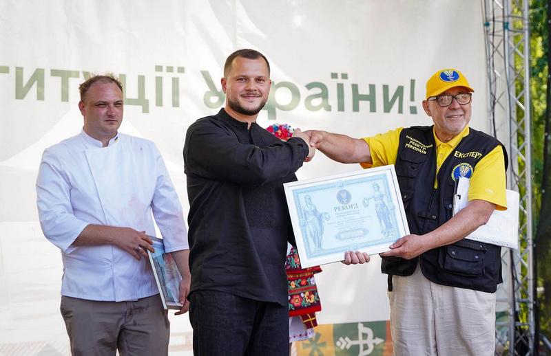 Голова Київської ОДА Микола Калашник тисне руку експерту Реєстру рекордів і тримає офіційний диплом про встановлення національного рекорду України.