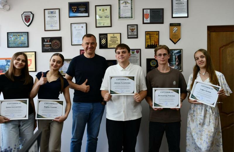 Вадим Токар разом із молоддю громади, які тримають у руках отримані сертифікати про проходження стажування в селищній раді