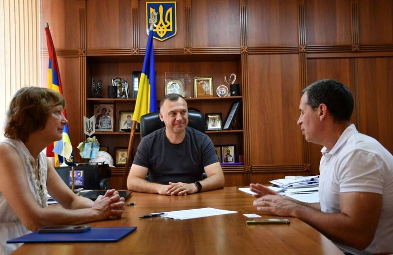 Макарівський селищний голова Вадим Токар спілкується з представниками Національного наукового центру за робочим столом у кабінеті.