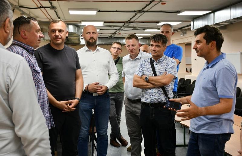 Польська делегація спілкується з Макарівським селищним головою всередині просторого відремонтованого безпечного укриття для дітей.
