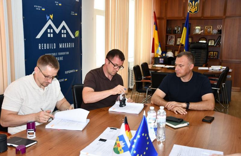 Підписання документів під час реалізації проєкту HOPE щодо технічної оцінки багатоквартирних будинків у Макарівській громаді.
