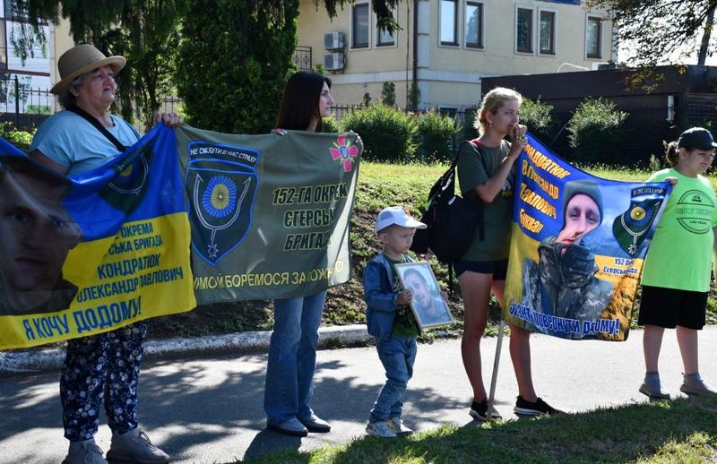 Учасники акції тримають синьо-жовті плакати з портретами полонених та зниклих бійців, серед них — дитина із портретом військового.