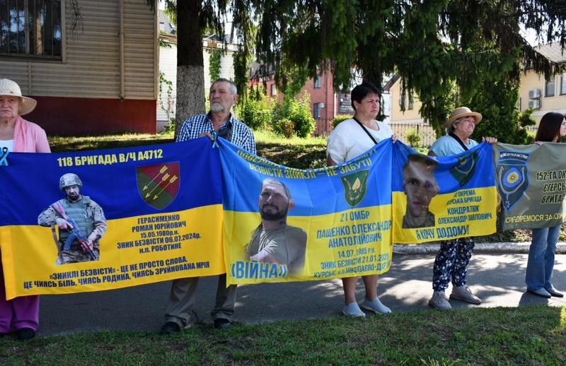 Учасники акції у Макарові тримають плакати із портретами та іменами українських військових, які вважаються зниклими безвісти.