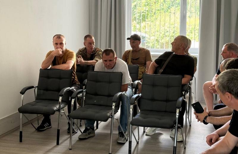 Ветерани та учасники зустрічі уважно слухають доповідачів під час обговорення проблеми дотримання тиші та соціальних послуг.