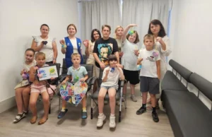 Спільне групове фото дітей та дорослих із фетровими серцями в руках у Ветеранському просторі «Серед Своїх» після завершення психологічного тренінгу.