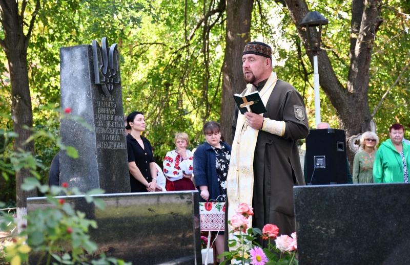 Священнослужитель читає молитву біля пам’ятного знака на Алеї пам’яті у Рожеві
