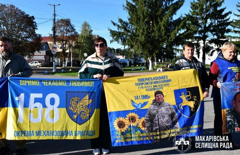 Учасники акції тримають синьо-жовті банери з фотографіями українських воїнів та закликами «Віримо, чекаємо, любимо!» і «Поверніть коханого».
