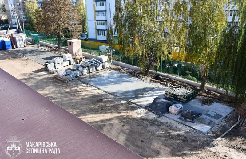 Вид зверху на територію дитячого садка, де триває бетонування основи під тіньовий навіс та впорядкування ділянки.