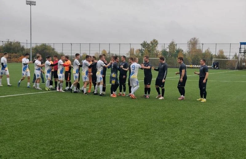 Традиційне привітання та рукостискання гравців суперницьких футбольних команд і суддівської бригади на зеленому газоні перед початком гри.